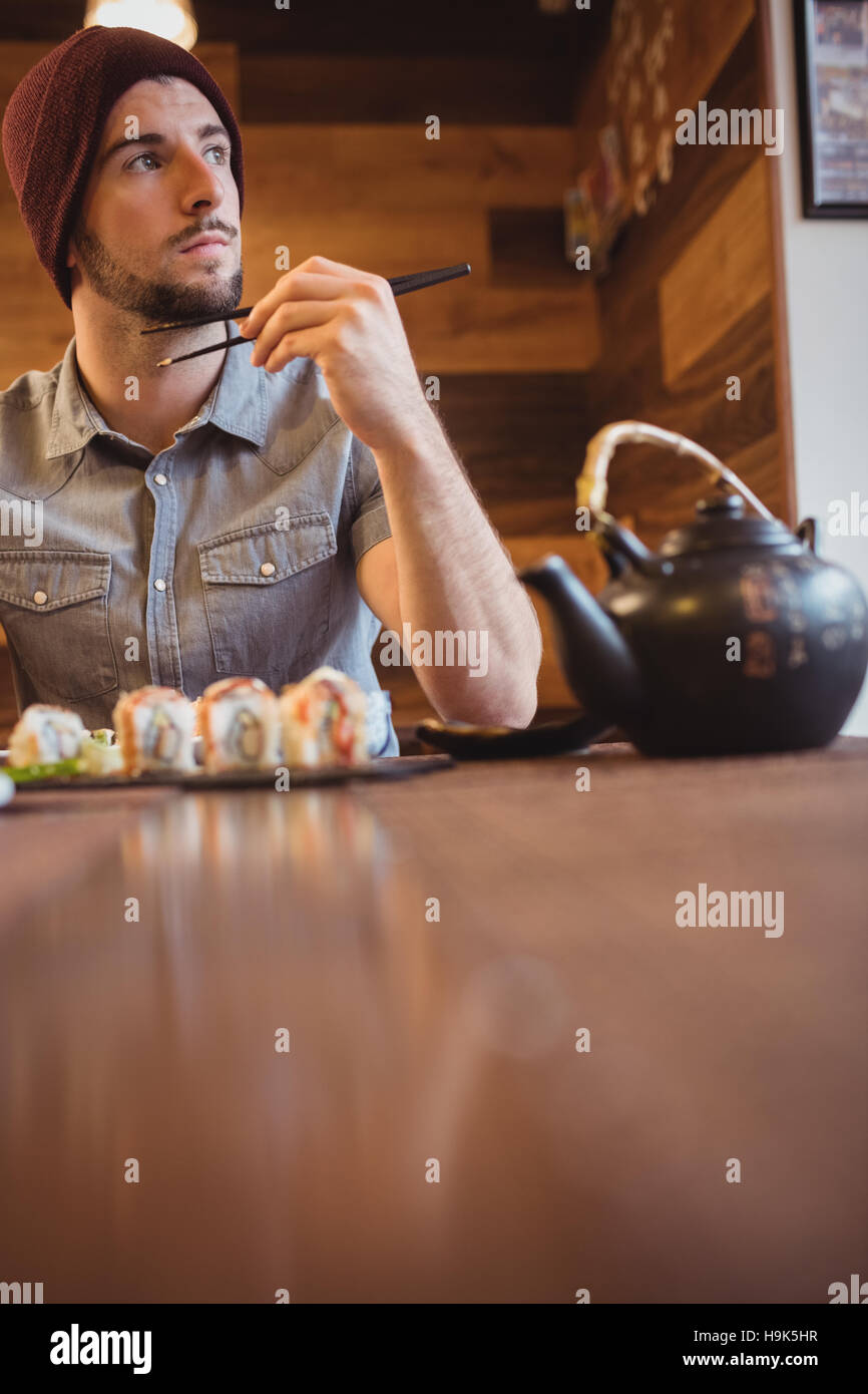 Man eating sushi in restaurant Stock Photo