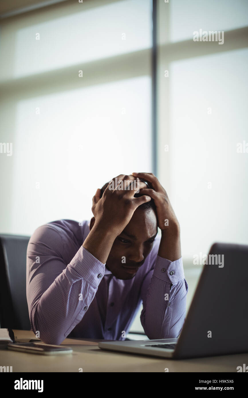 Frustrated business executive working on laptop Stock Photo