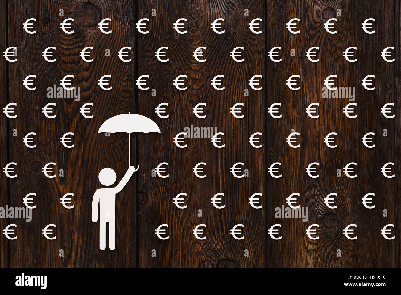 Man with umbrella standing in rain of euro, money concept Stock Photo