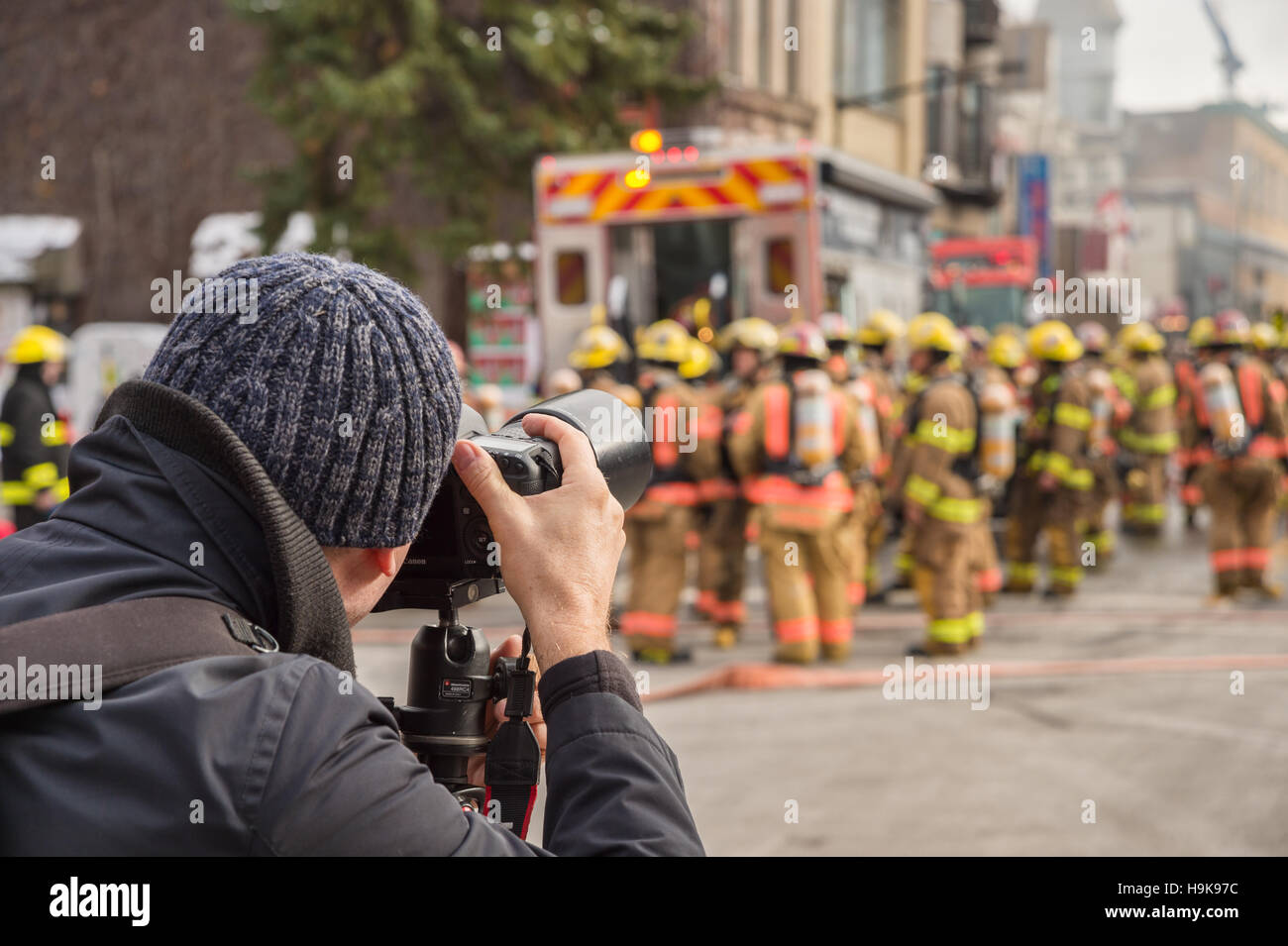 Montreal, CA - 23 Nov 2016: Photographer taking pictures of Montreal Firefighters working on 'Cafe Amusement 68' building on fire, 3464 Park Avenue. Stock Photo