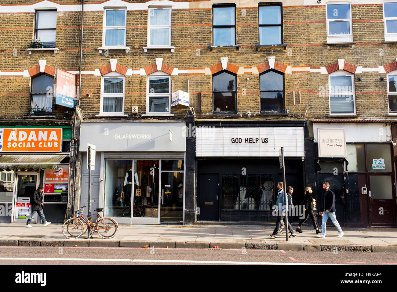 Trendy young people walking in Stoke Newington Road in front of cool indie shops. Shot in Dalston, East london. Stock Photo