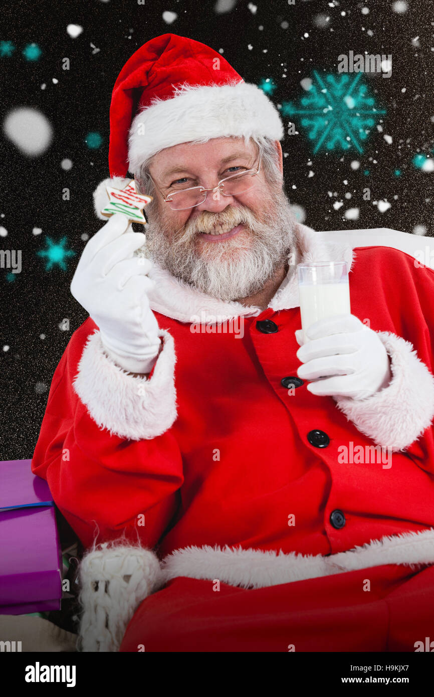Composite image of santa claus holding glass of milk and star shape cookie Stock Photo