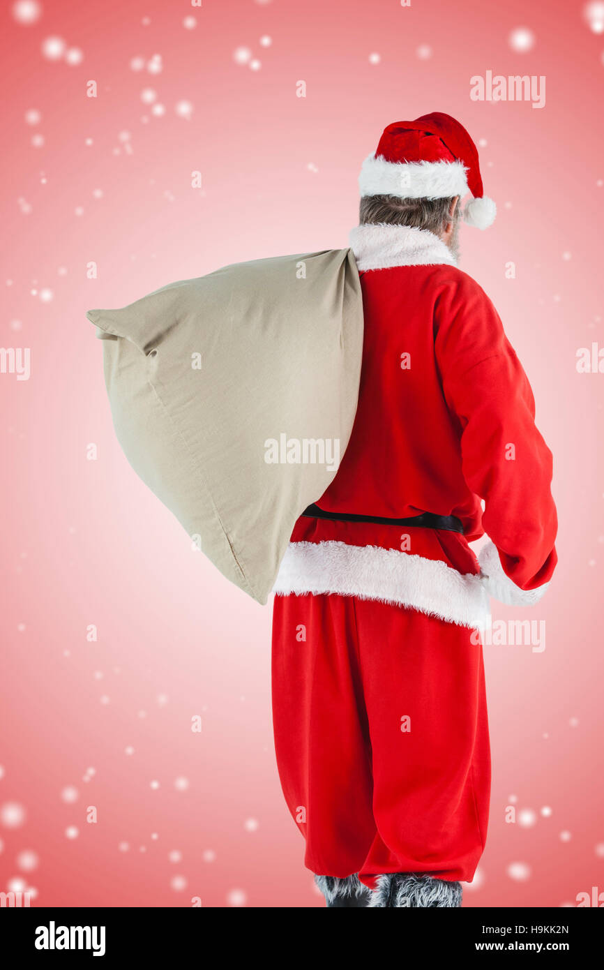 Composite image of santa claus carrying gifts in sack Stock Photo - Alamy