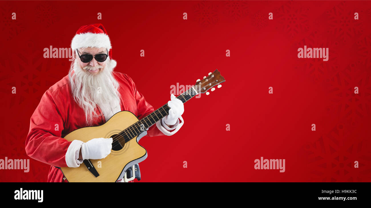 Composite image of smiling santa claus playing guitar while standing Stock Photo