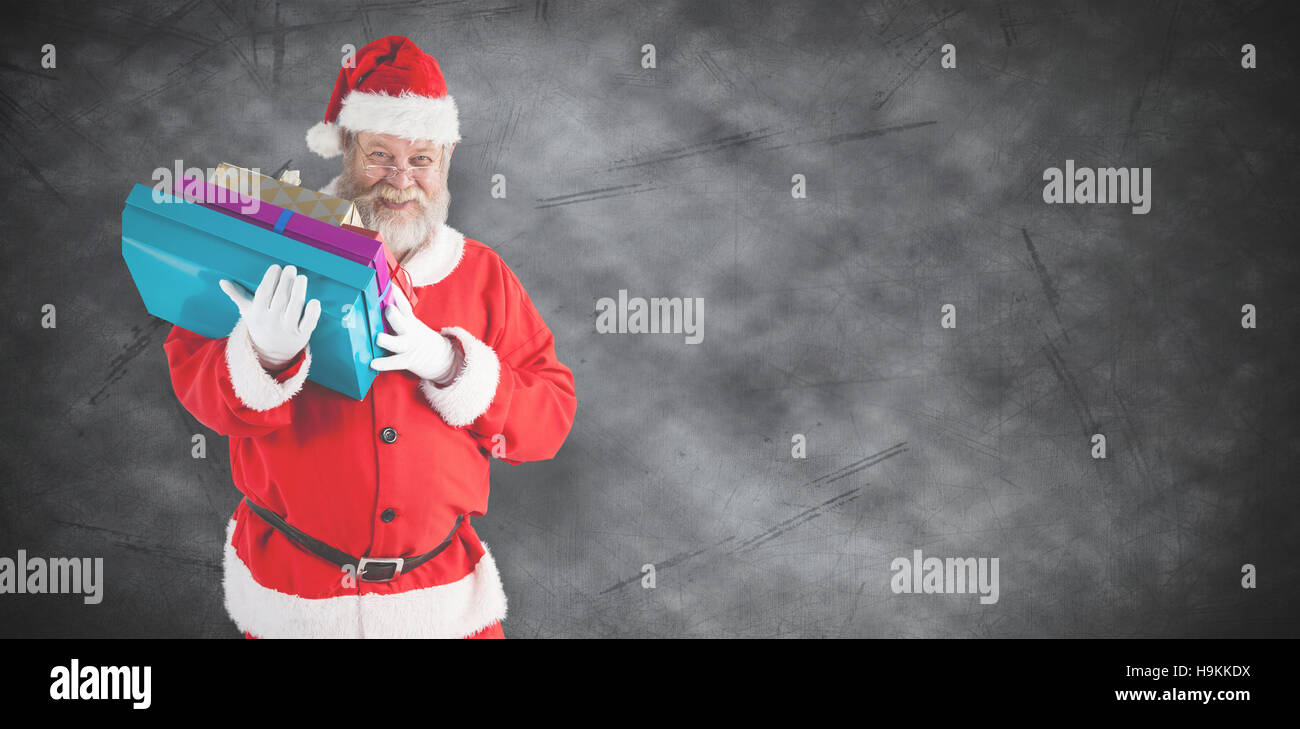 Composite image of santa claus holding christmas presents Stock Photo