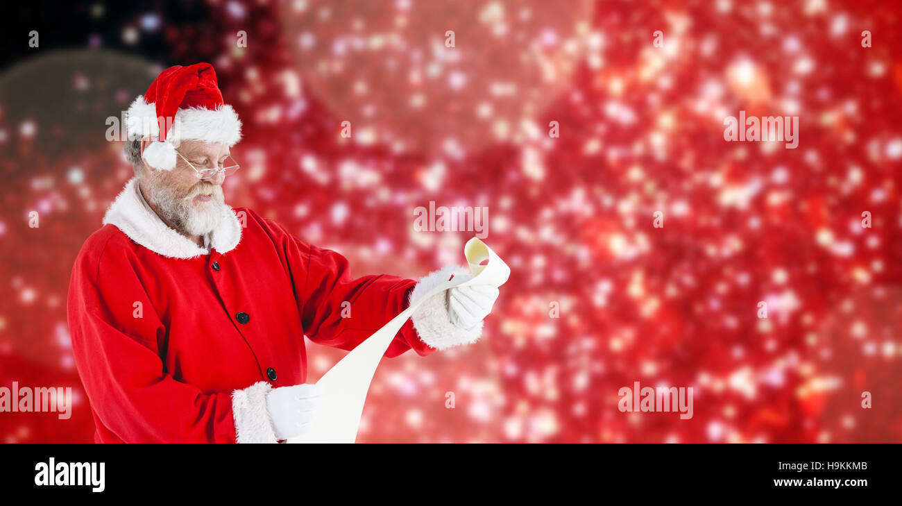 Composite image of santa claus smiling and reading scroll Stock Photo