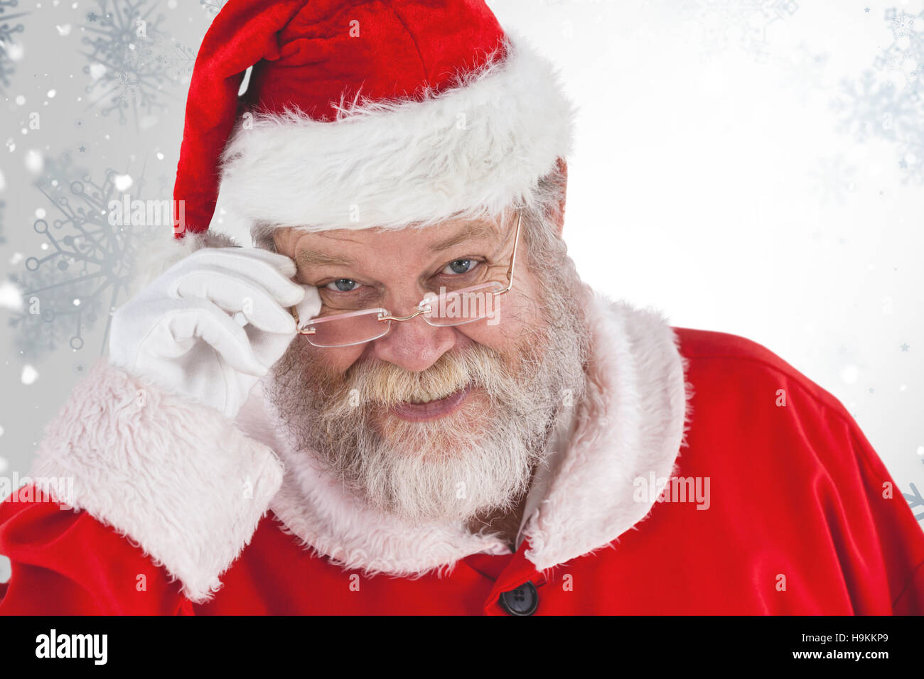 Composite image of santa claus holding spectacles Stock Photo