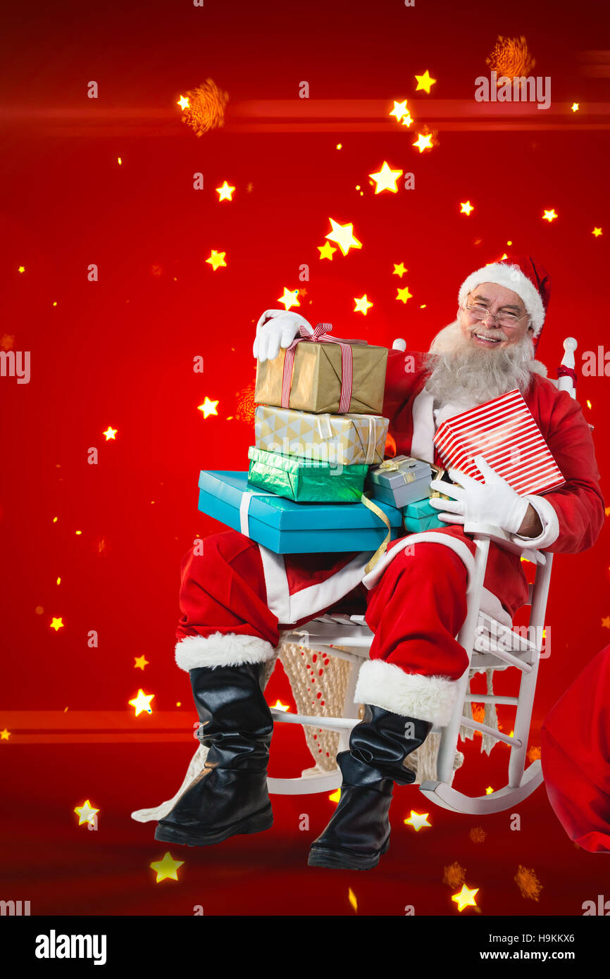 Composite image of portrait of santa claus holding stack of christmas presents Stock Photo