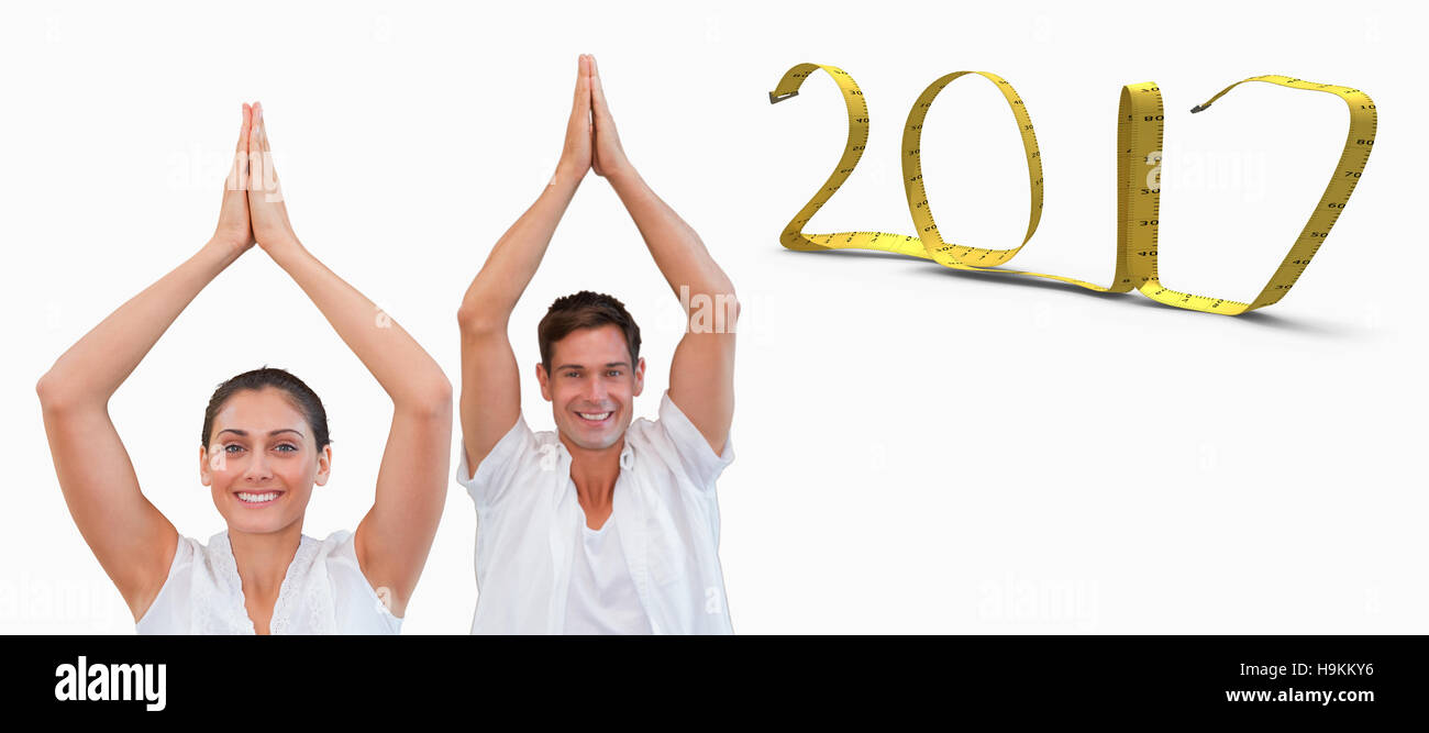 3D Composite image of peaceful couple in white doing yoga together with hands raised Stock Photo