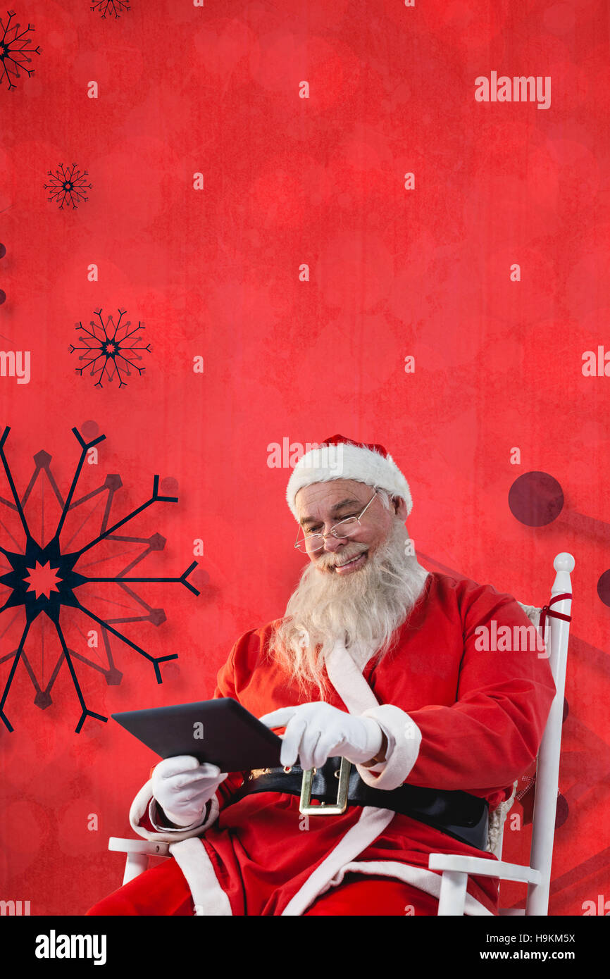 Composite image of smiling santa claus using digital tablet Stock Photo ...