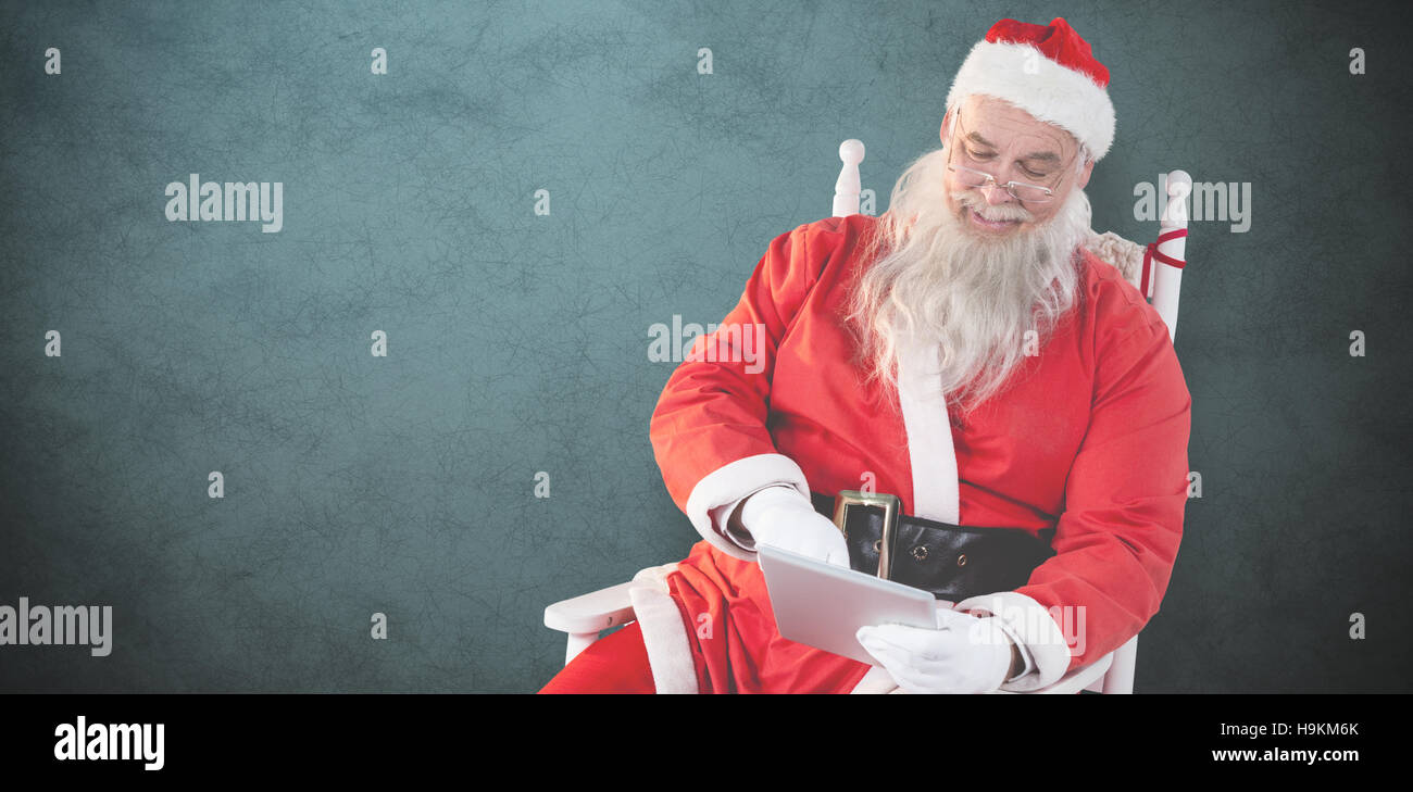 Composite image of santa claus using digital tablet Stock Photo - Alamy