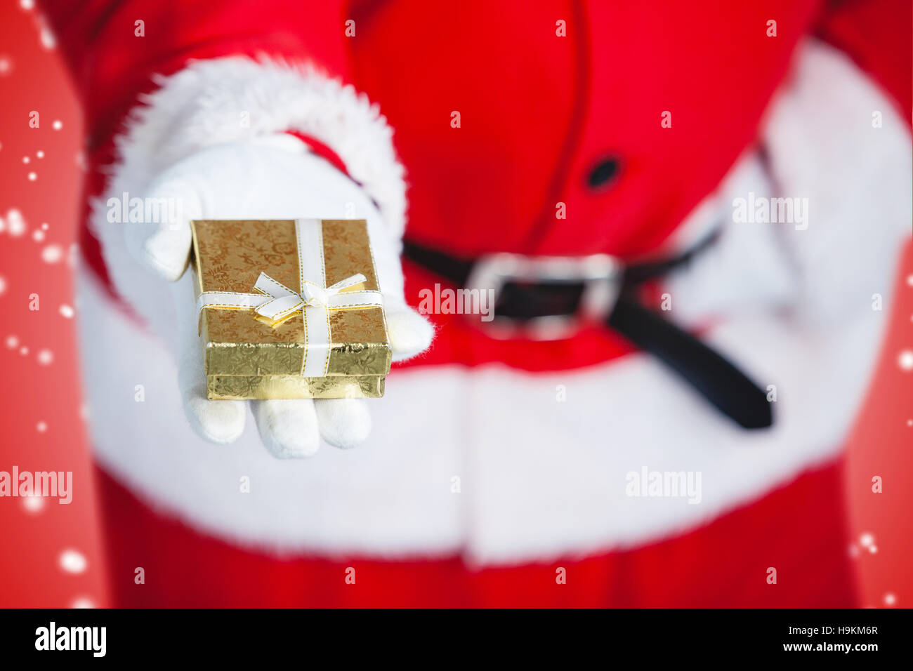 Composite image of santa claus holding a gift box in hand Stock Photo