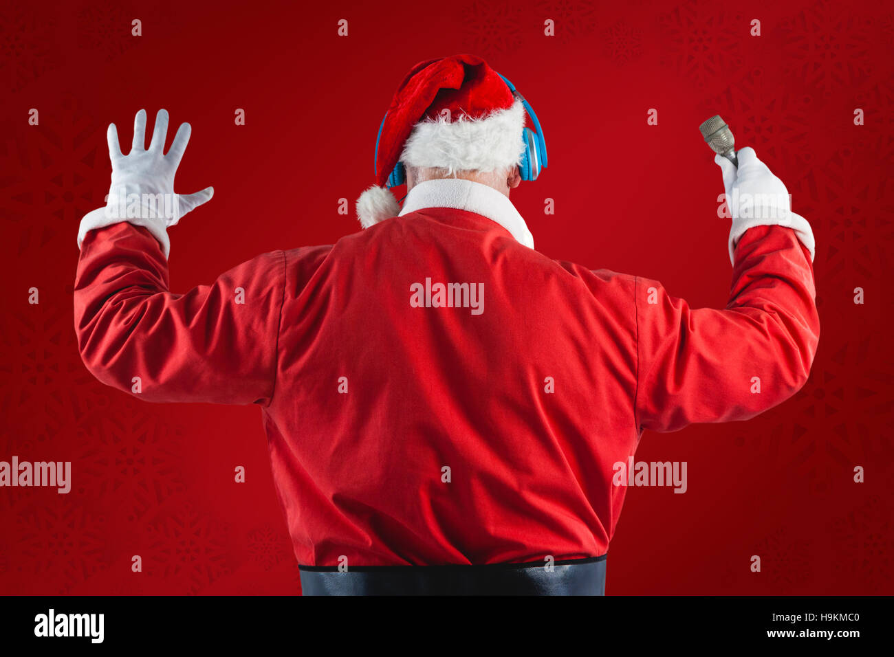 Composite image of rear view of santa claus listening to music Stock Photo