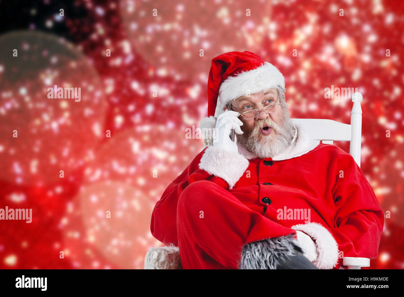 Composite image of surprised santa claus comunicating on mobile phone Stock Photo