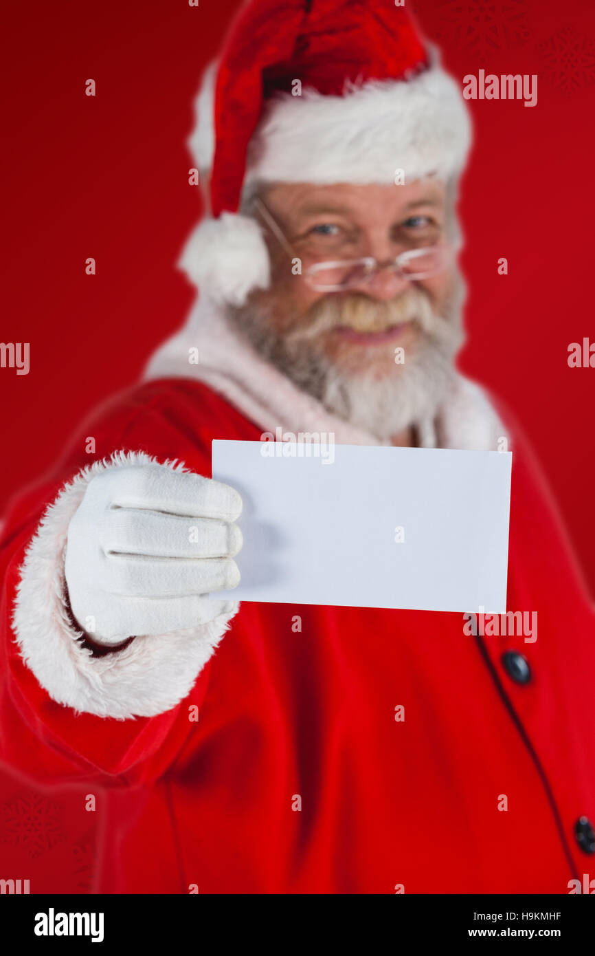Composite image of portrait of santa claus holding blank paper Stock Photo