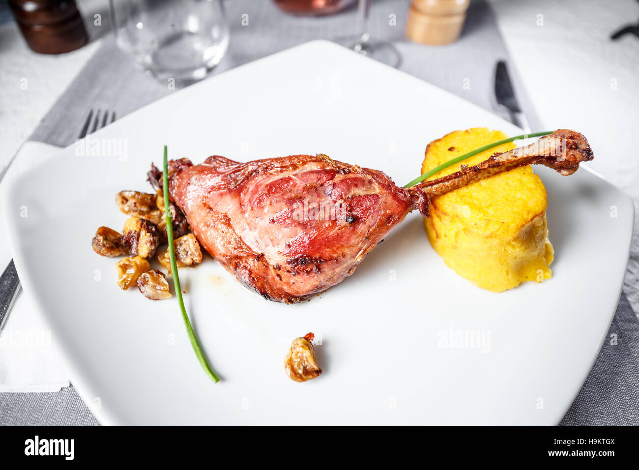 Roasted goose drumstick served with mashed potatoes and chestnuts Stock Photo