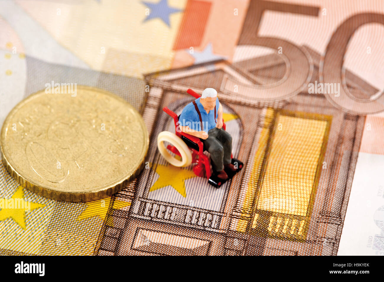 Figurine of a man in a wheelchair on a euro bill Stock Photo