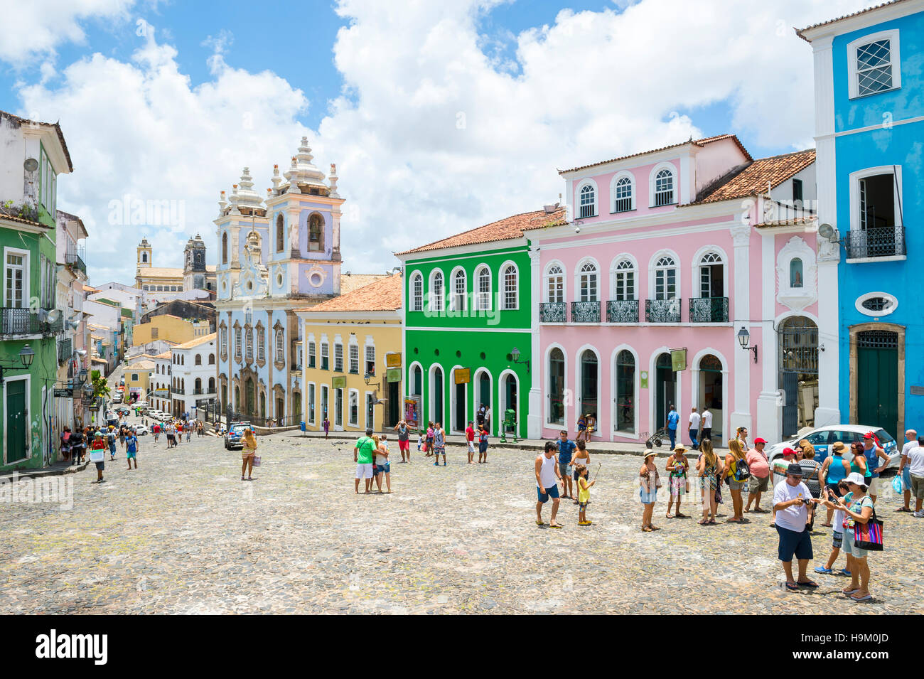 SALVADOR, BRAZIL - MARCH 12, 2015: Visitors pass through the traditional plaza surrounded by colonial buildings in Pelourinho. Stock Photo
