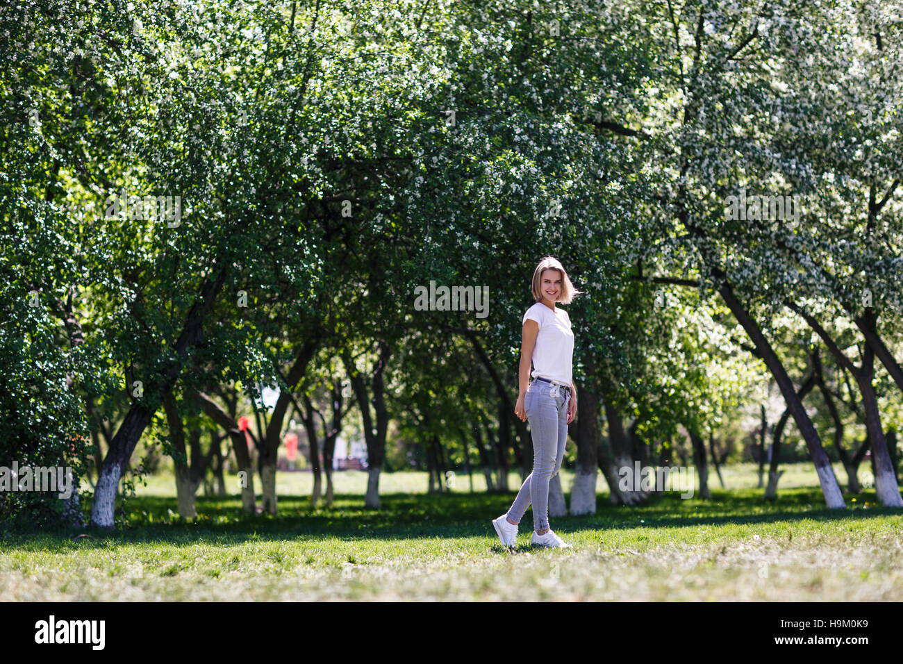 Young woman in blooming spring garden. Stock Photo