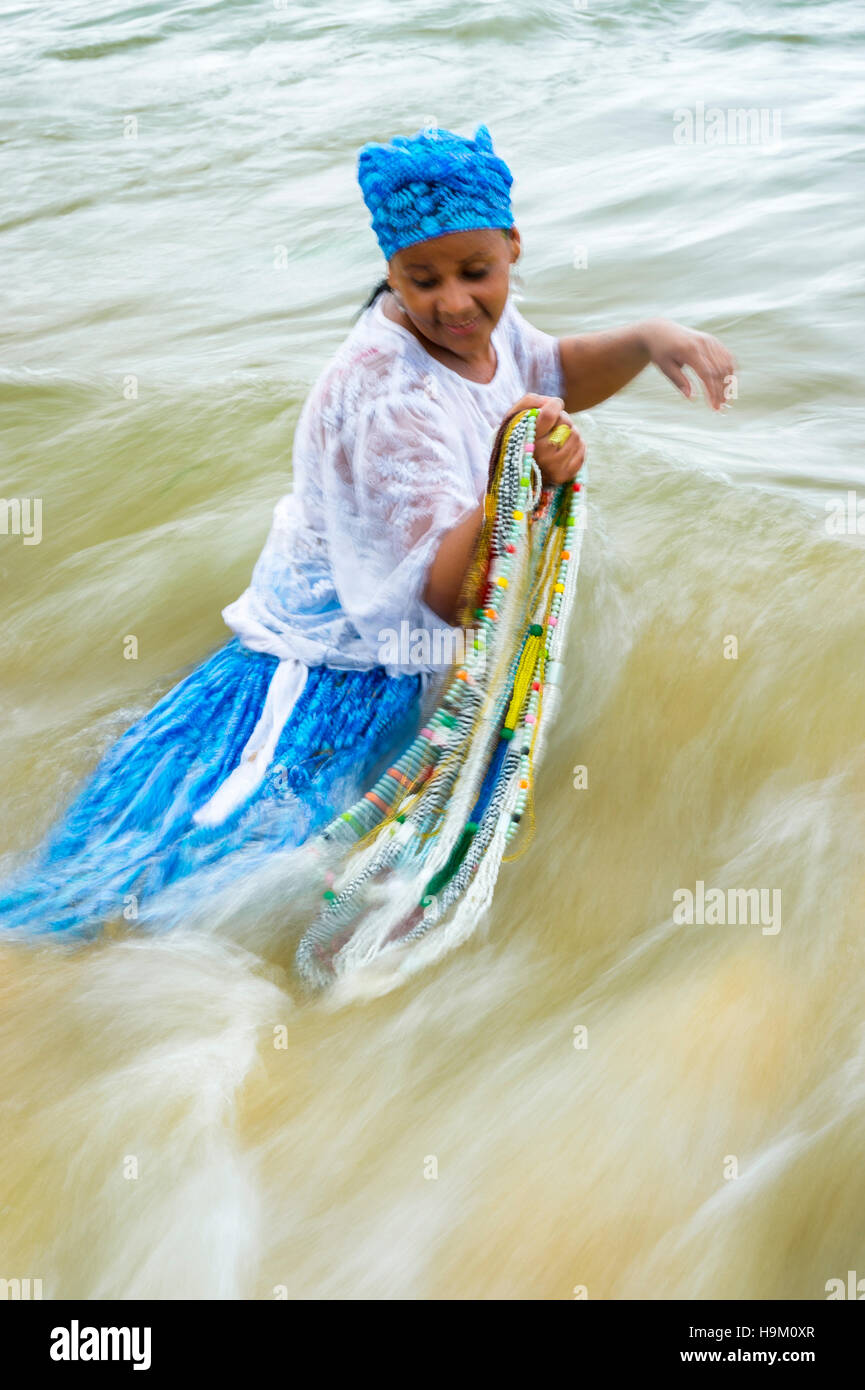 SALVADOR, BRAZIL - FEBRUARY 02, 2016: Worshippers dressed in traditional costume at the Festival of Yemanja wade into the sea. Stock Photo