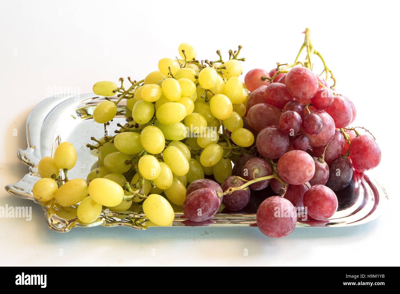 Red and Green Grapes on a silver plate, food closeup Stock Photo