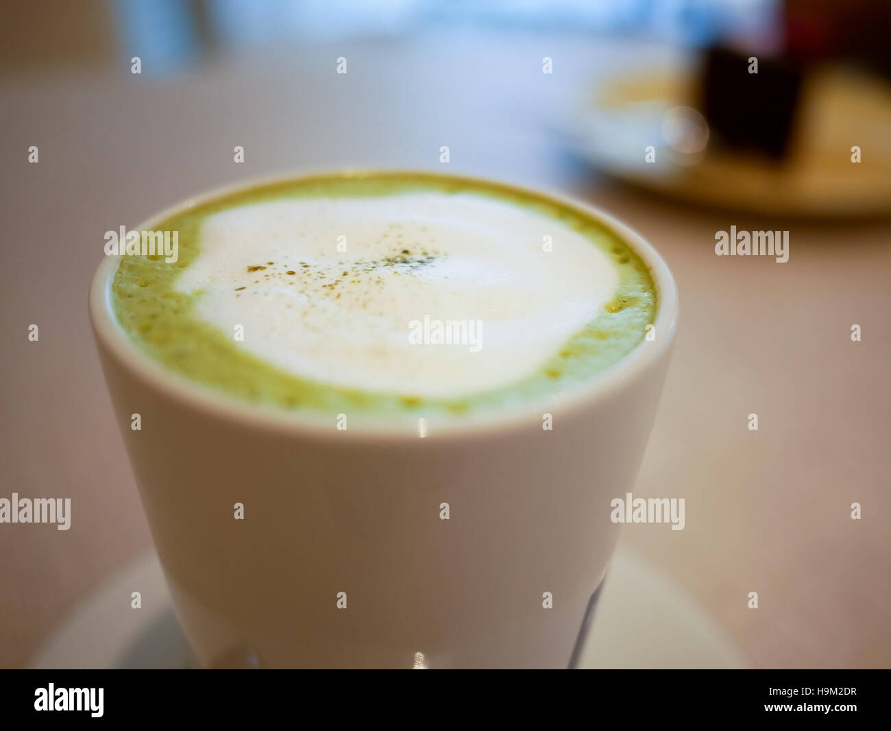 Hot macha green tea latte on a white cup Stock Photo