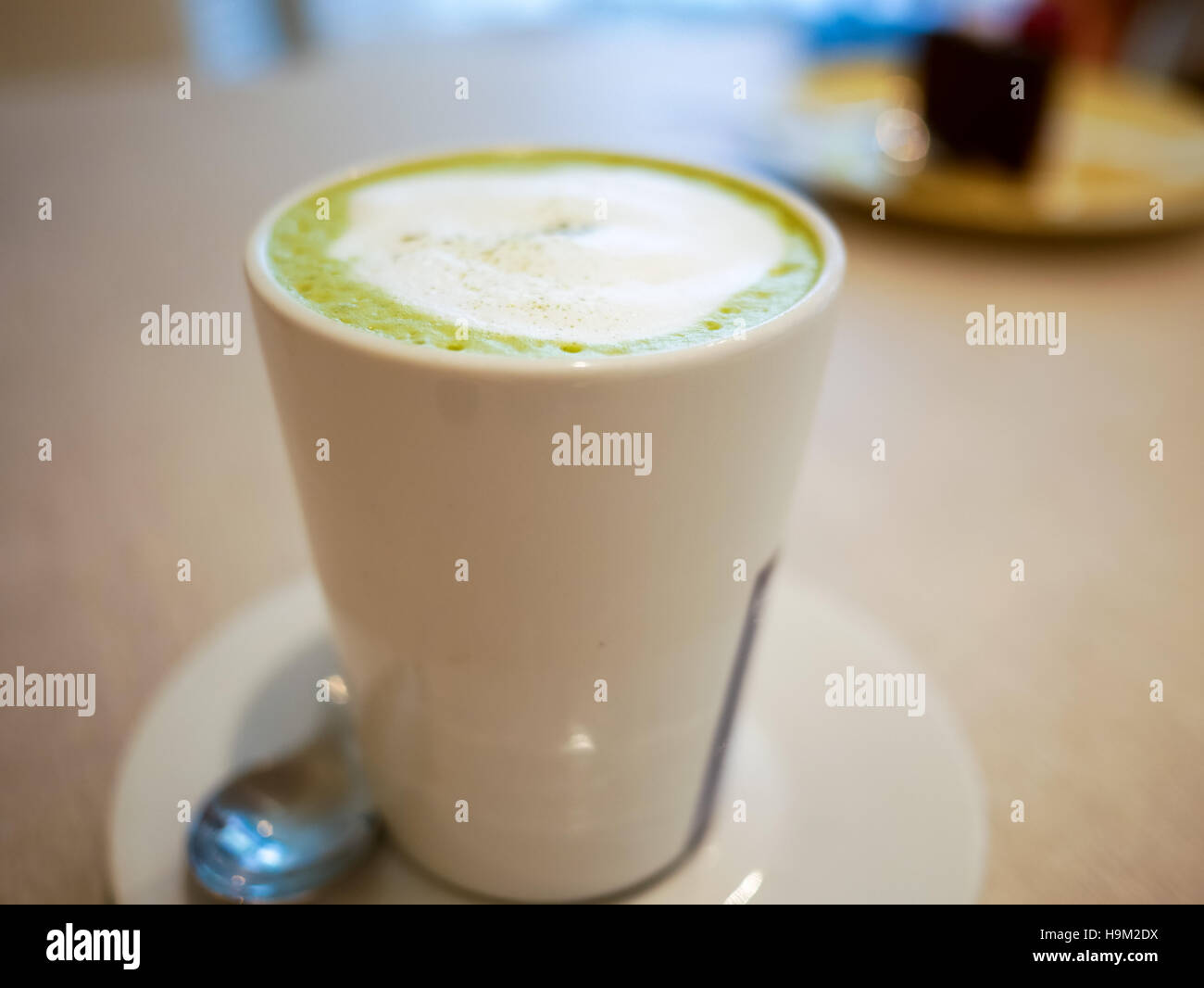Hot macha green tea latte on a white cup Stock Photo