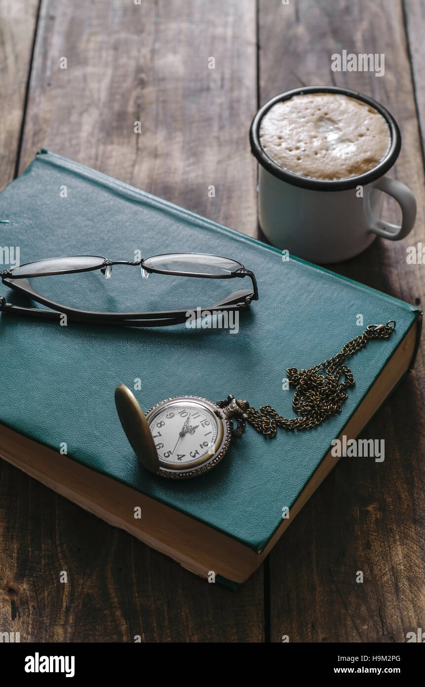 Vintage pocket watch,  old book and coffee Stock Photo