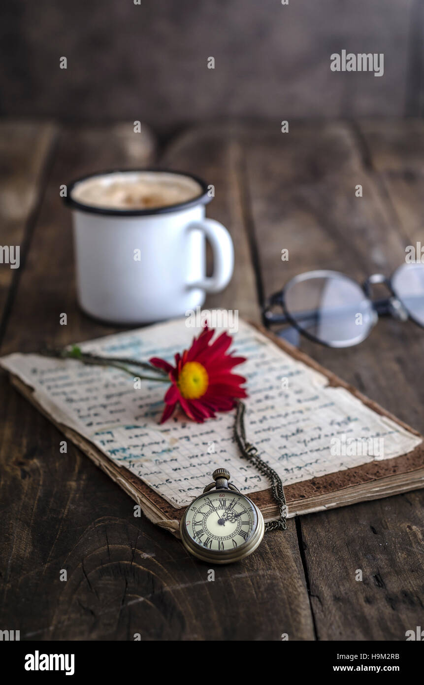 Vintage pocket watch with cup of coffee on old wooden background Stock Photo