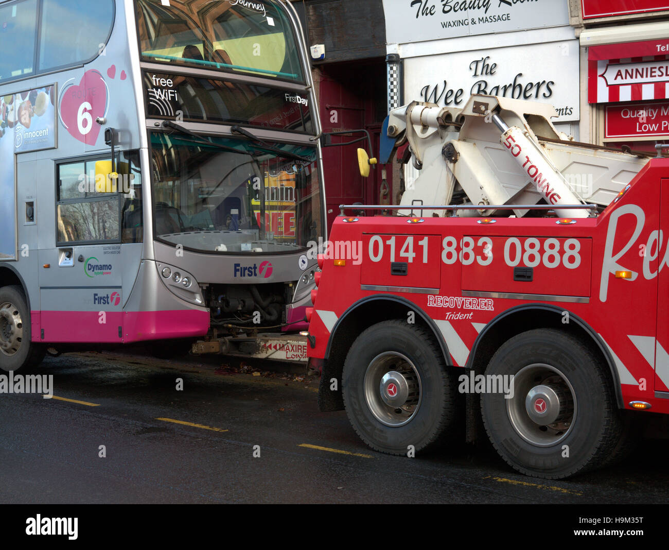 Broken down firstbus  bus with recovery vehicle tow towed towing Stock Photo