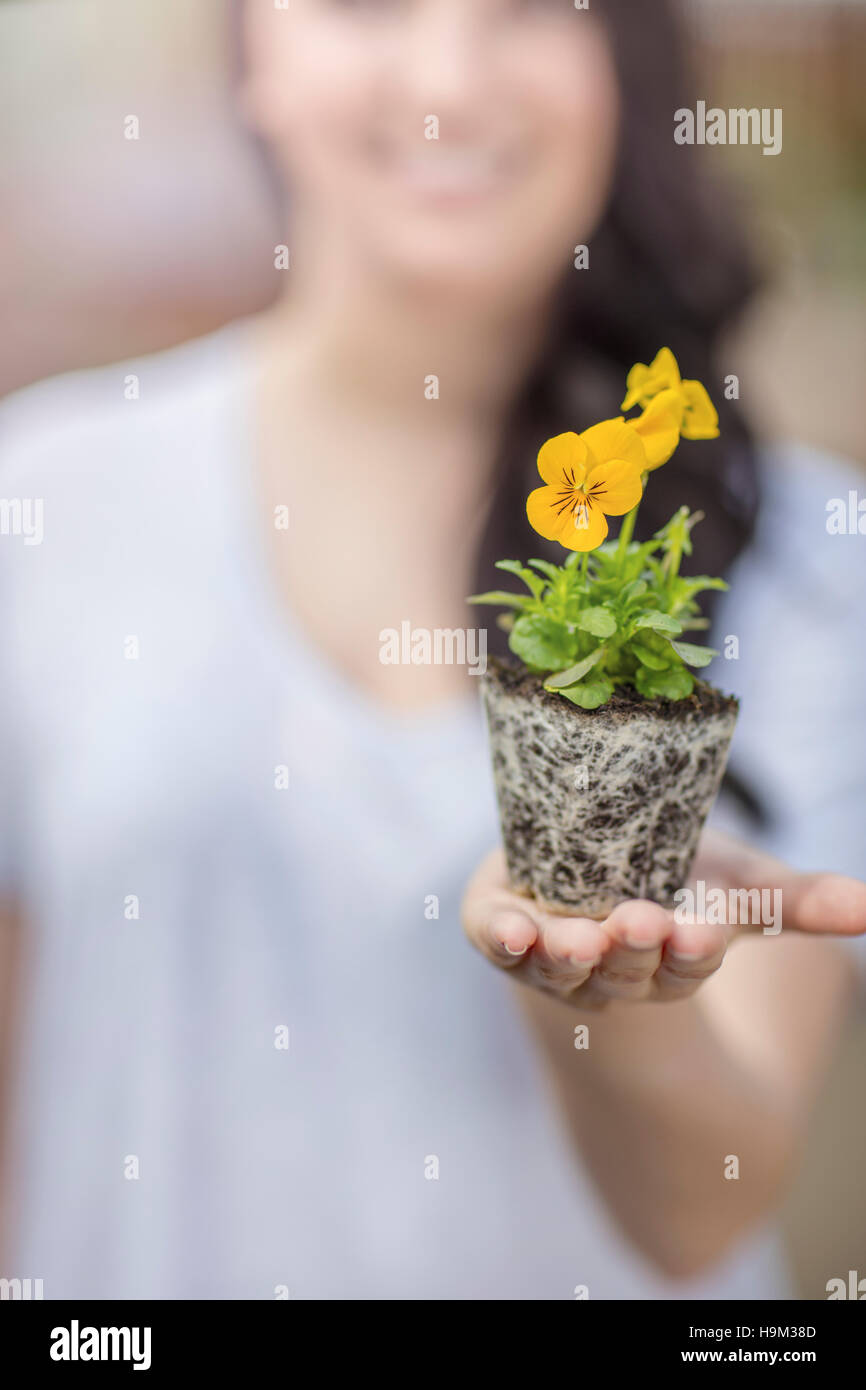 Woman holding plant in garden centre Stock Photo - Alamy