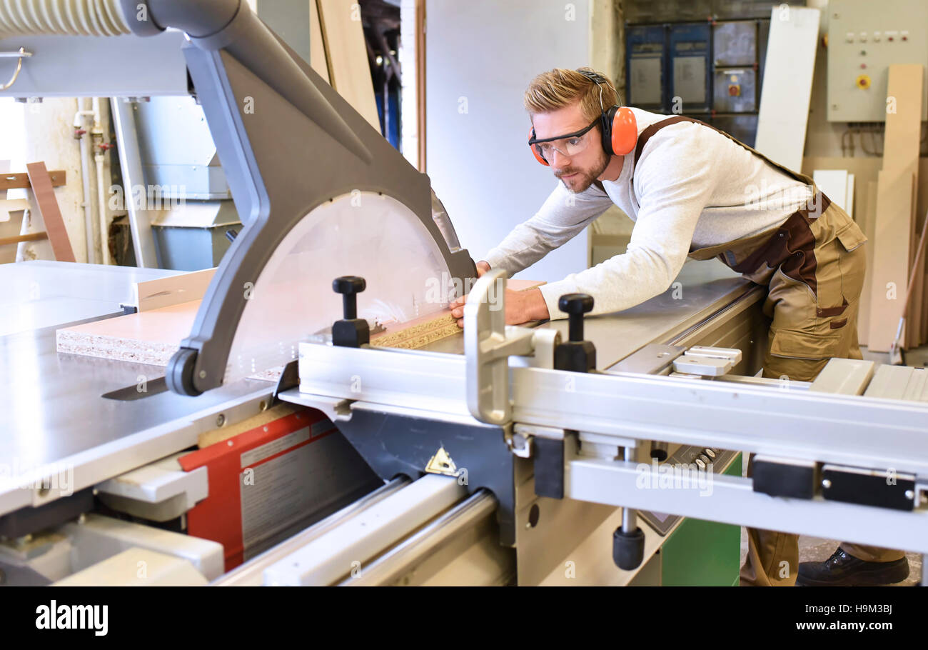 Carpenter using sawing machine in his workshop Stock Photo - Alamy