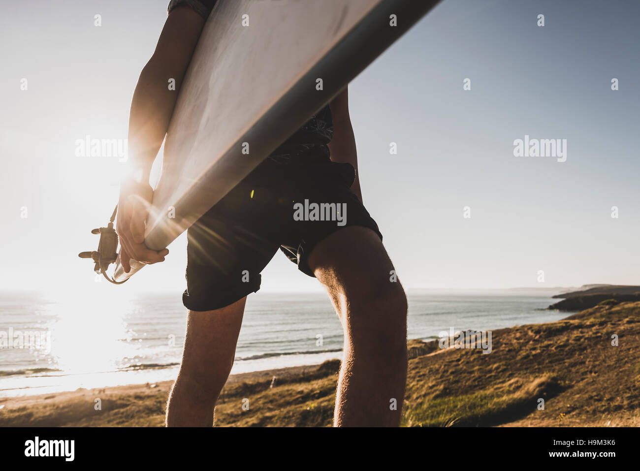 Teenage boy with surfboard at seaside, partial view Stock Photo