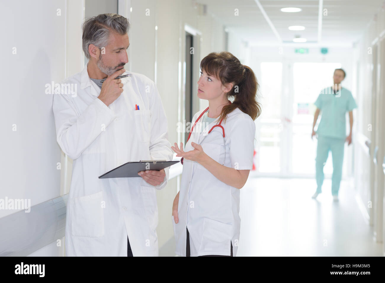 Medical workers in discussion in hospital corridor Stock Photo - Alamy