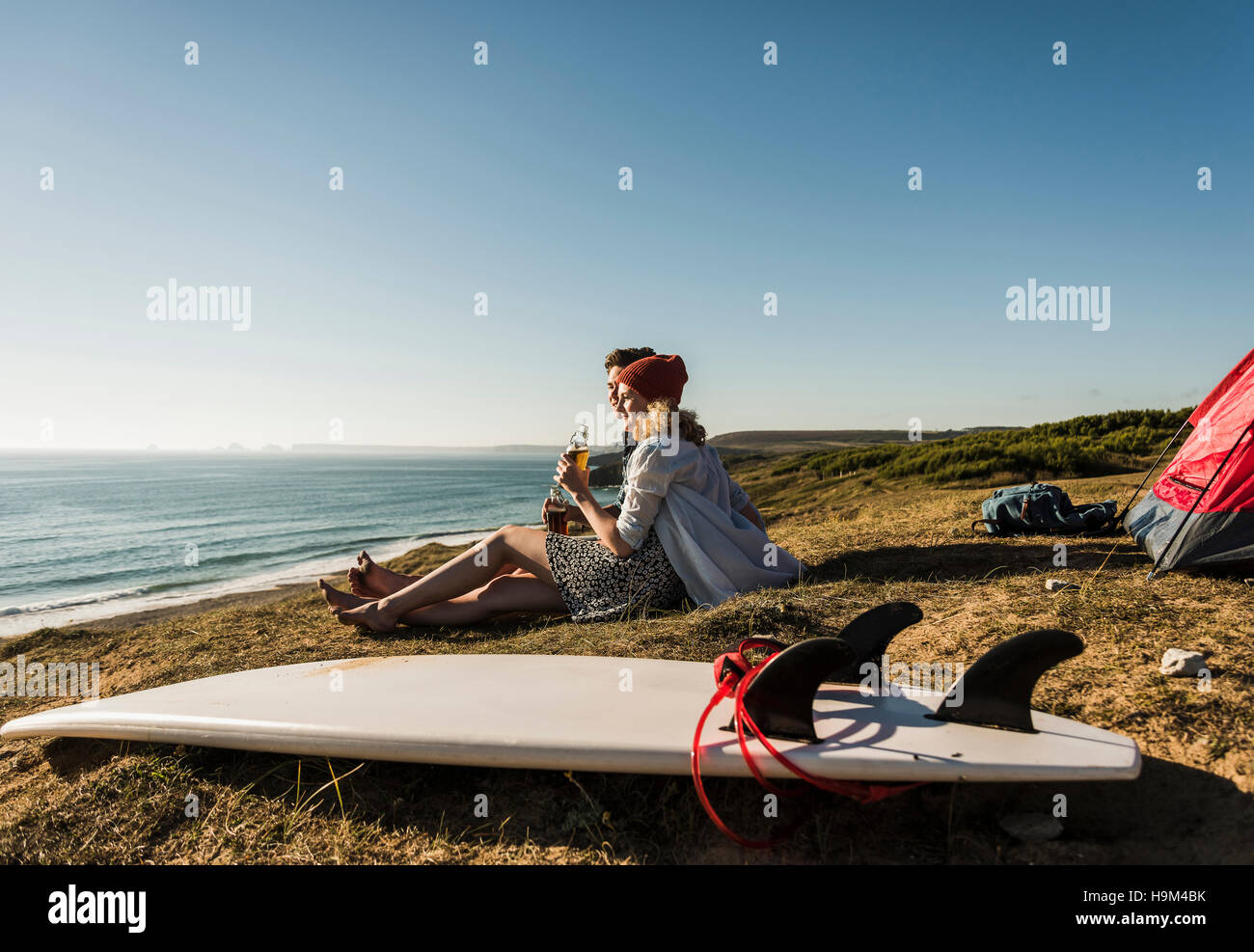Young couple with surfboard camping at seaside Stock Photo