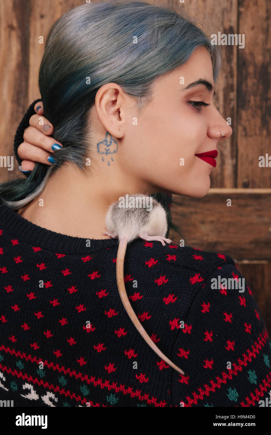 Young woman with pet rat on her shoulder wearing patterned knit pullover Stock Photo