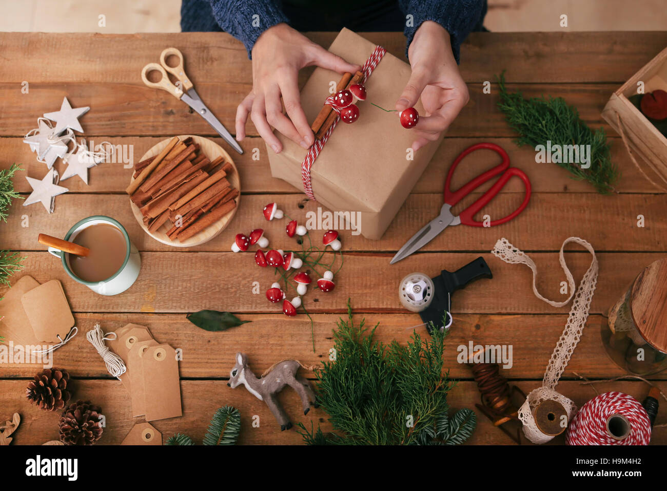 Woman's hands decorating Christmas present Stock Photo