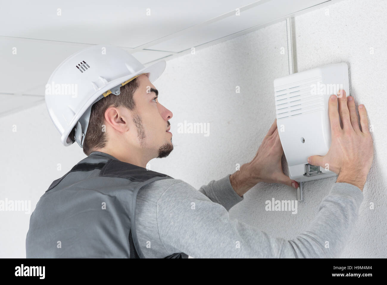 technician checks burglar alarm in professional building Stock Photo