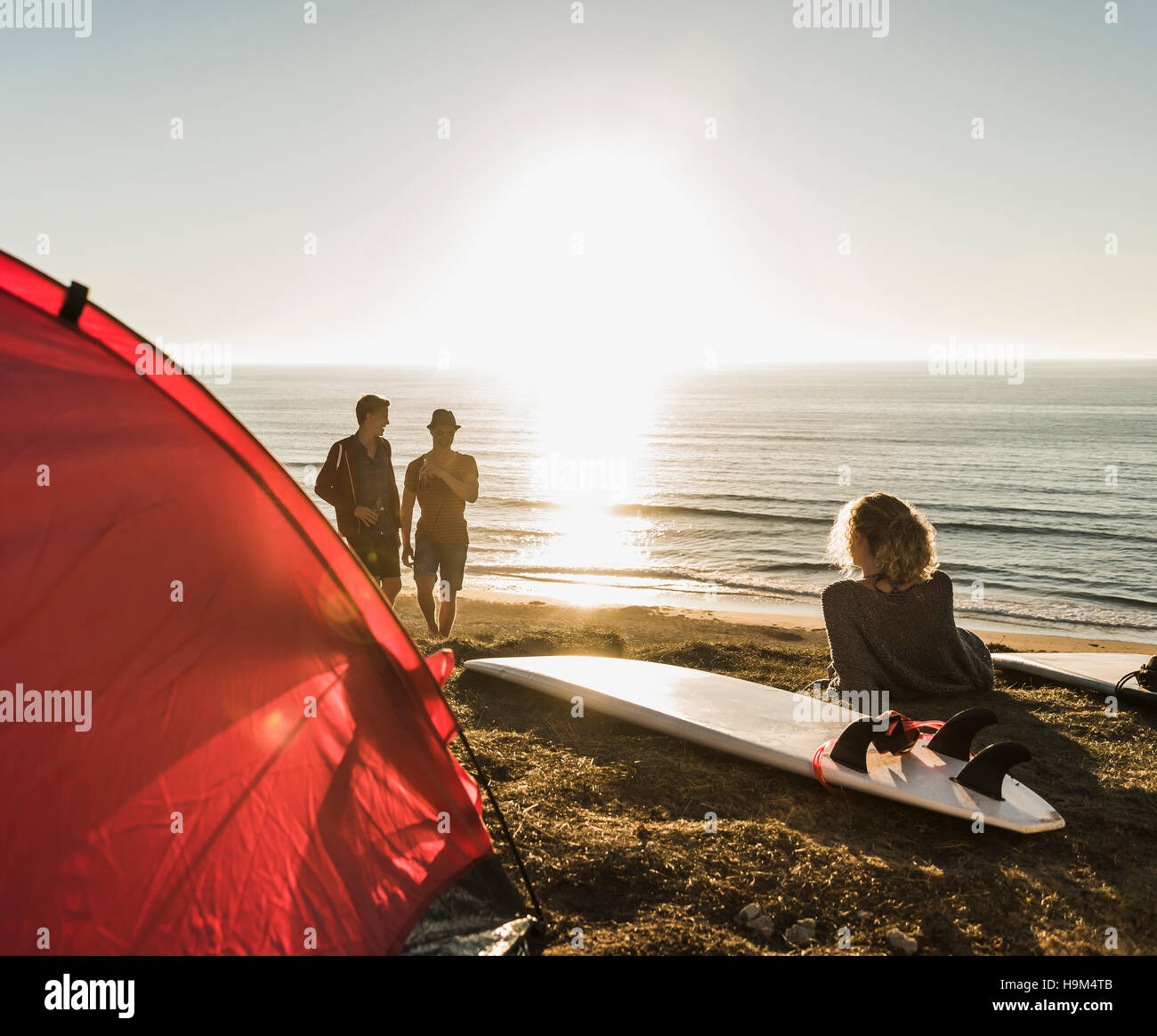 Three friends camping at seaside Stock Photo