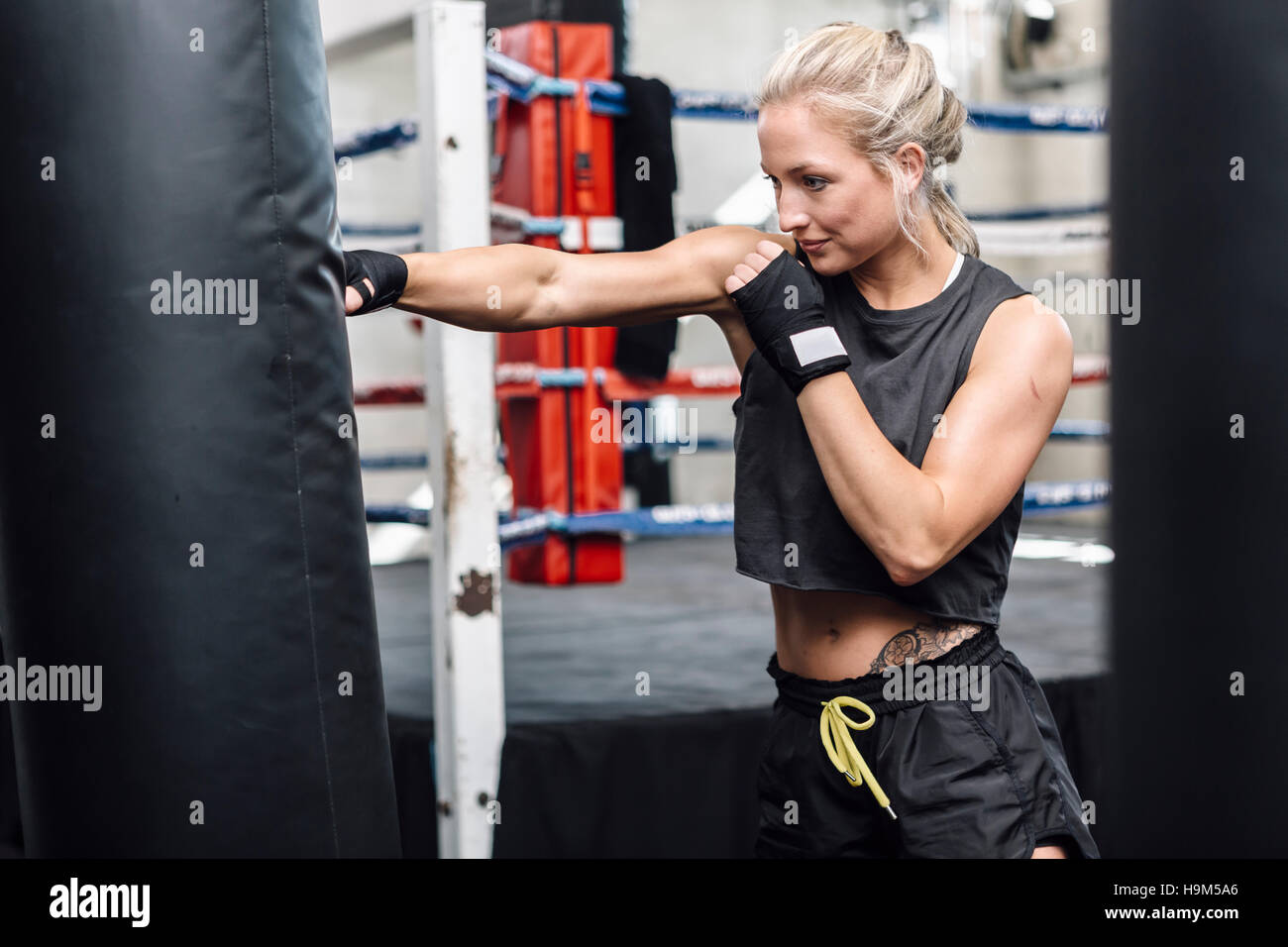 Female boxer exercising at punch bag Stock Photo