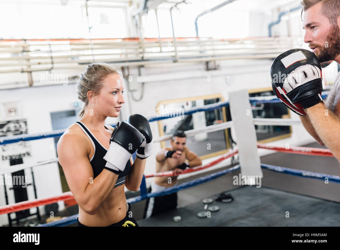 Female boxer sparring with coach Stock Photo