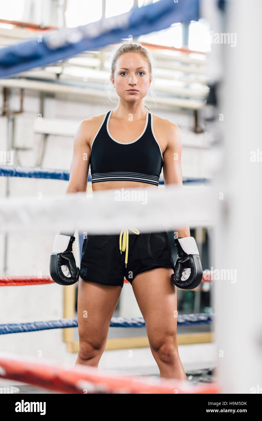 Portrait of confident female boxer in boxing ring Stock Photo
