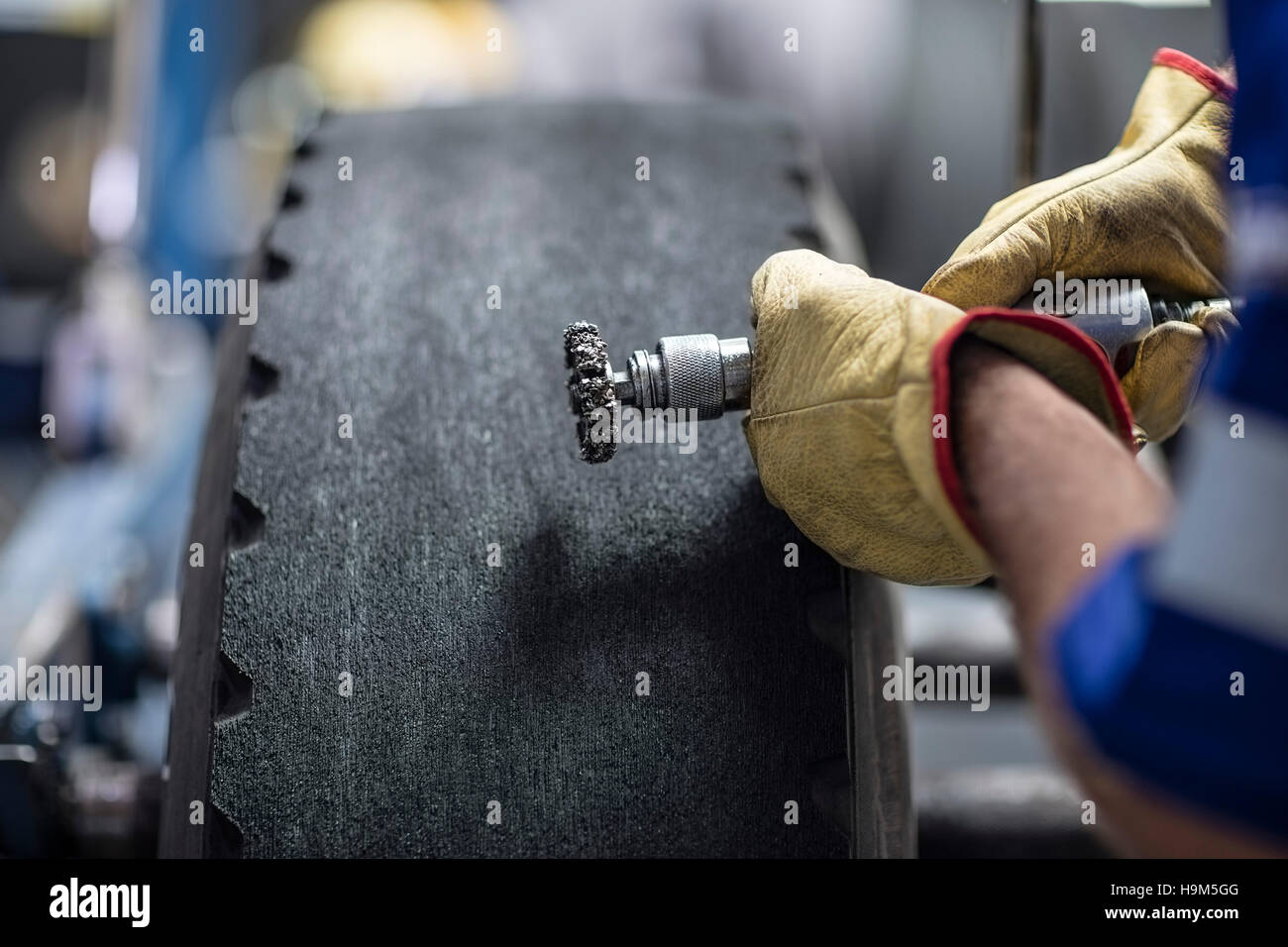Repairman with tire tread cutting machine Stock Photo