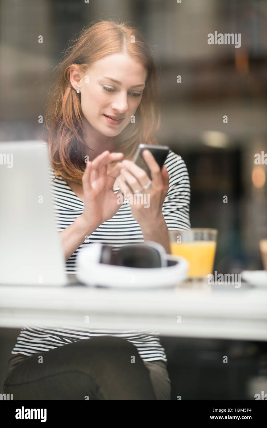 Portrait of woman text messaging in a coffee shop Stock Photo - Alamy