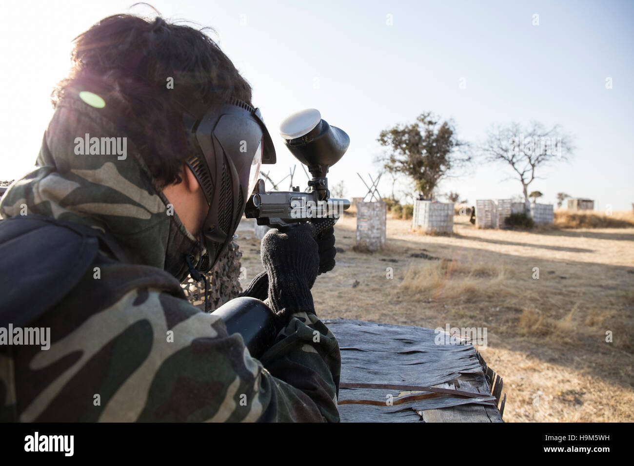 Paintball player aiming with paintball gun during a paintball game