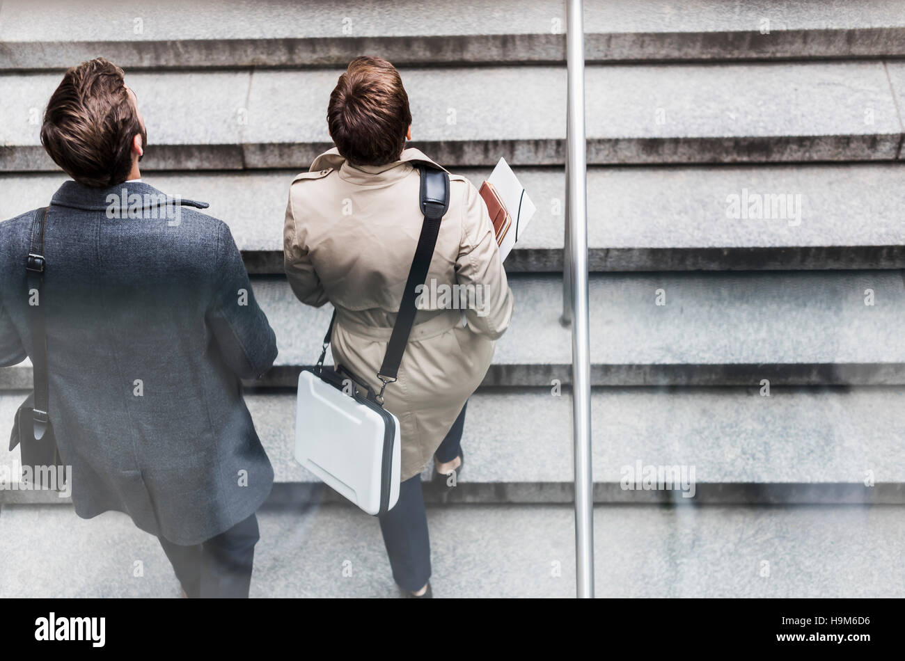 Businessman and woman walking on stairs Stock Photo - Alamy