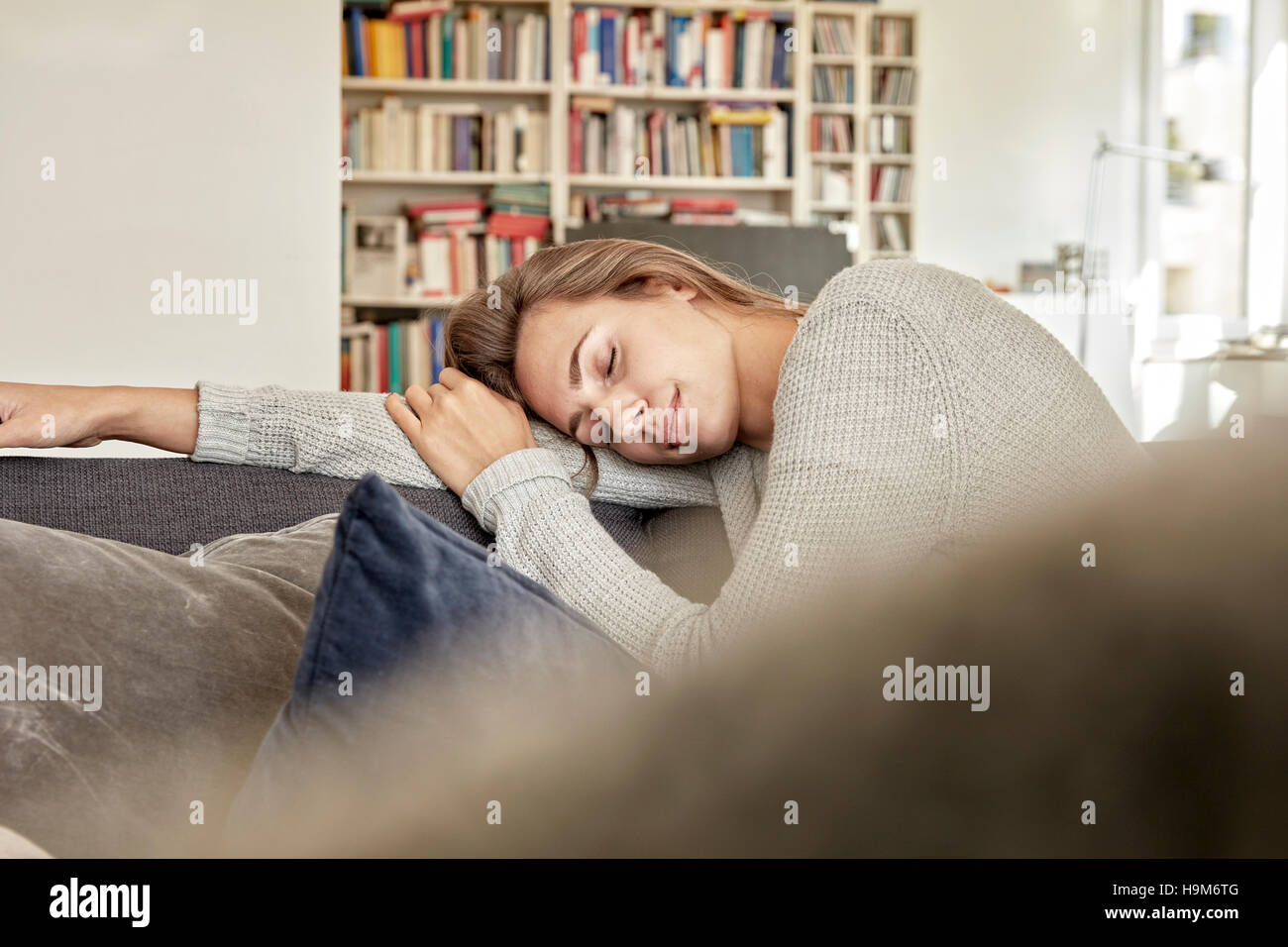 Young woman relaxing with eyes closed on couch in the living room Stock ...