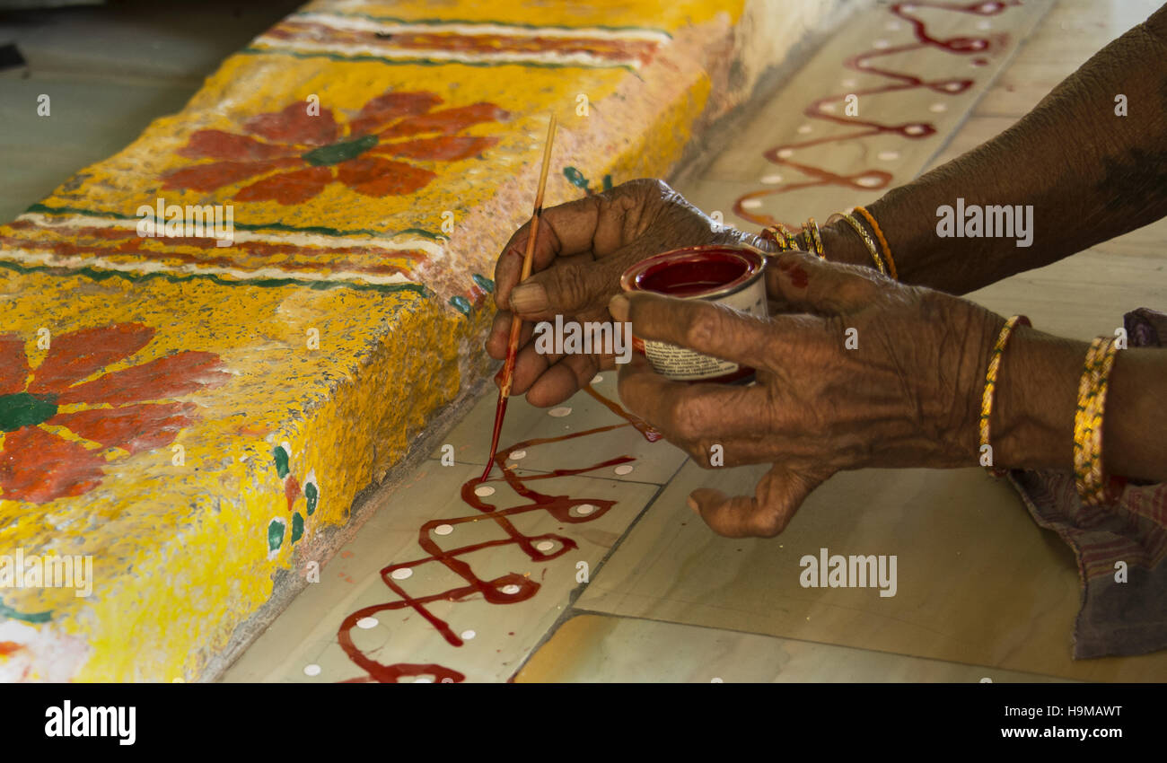 woman painting on steps of Hindu temple Stock Photo
