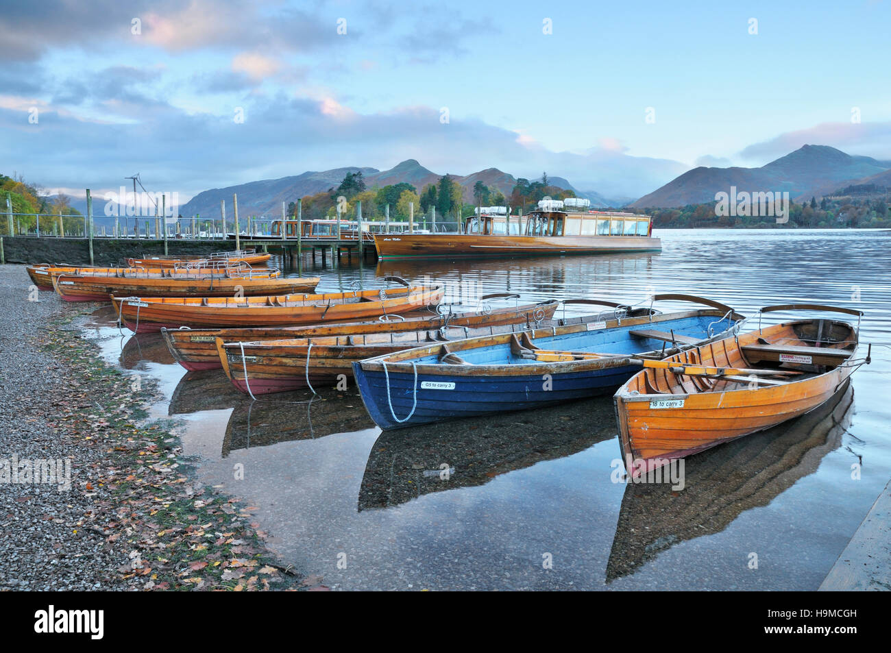 Classic view of wooden boats on Derwentwater at sunrise set against Catbells and Causey Pike, Keswick, Lake District, UK Stock Photo