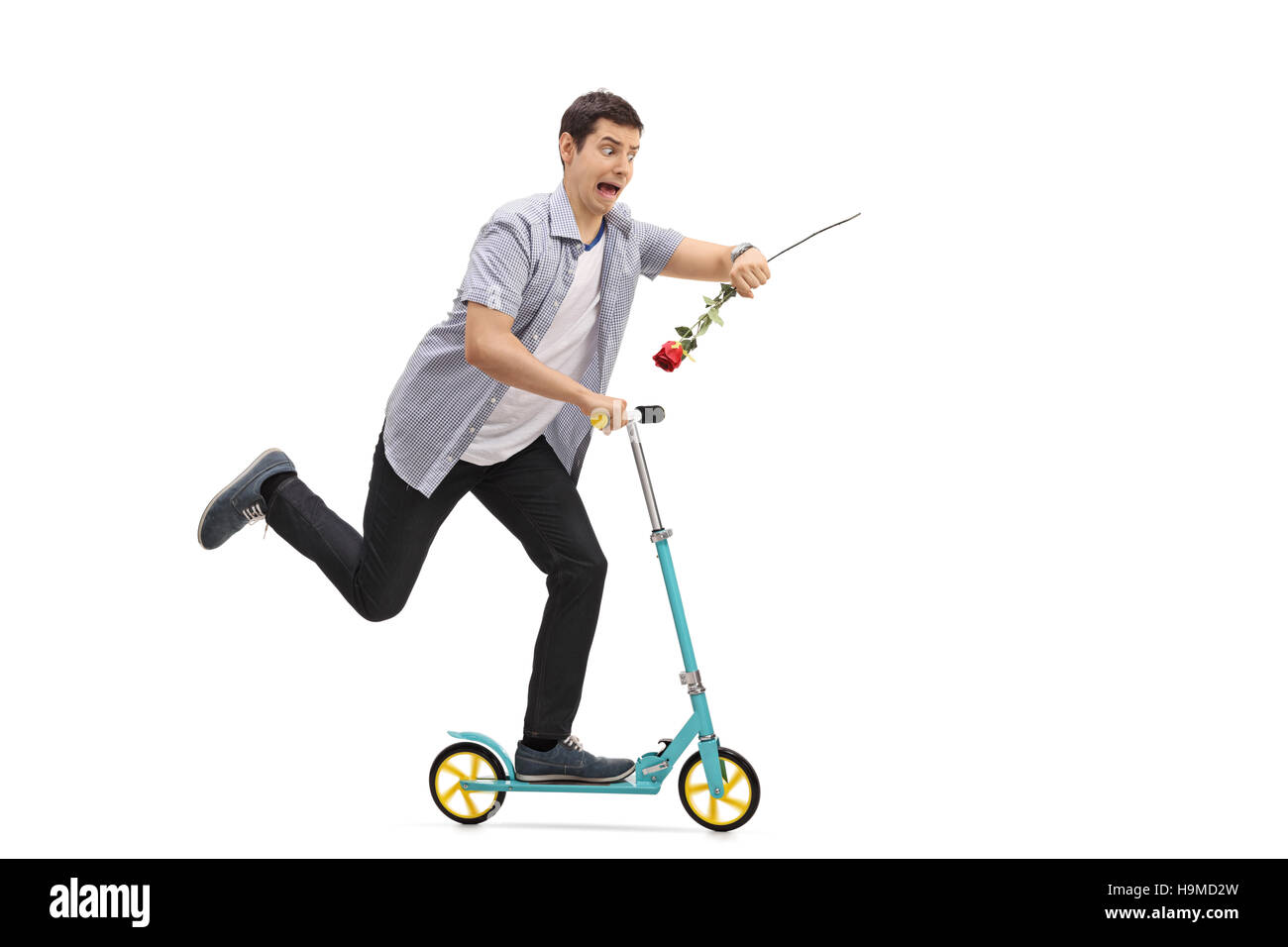Full length portrait of a young man riding a scooter and being late isolated on white background Stock Photo